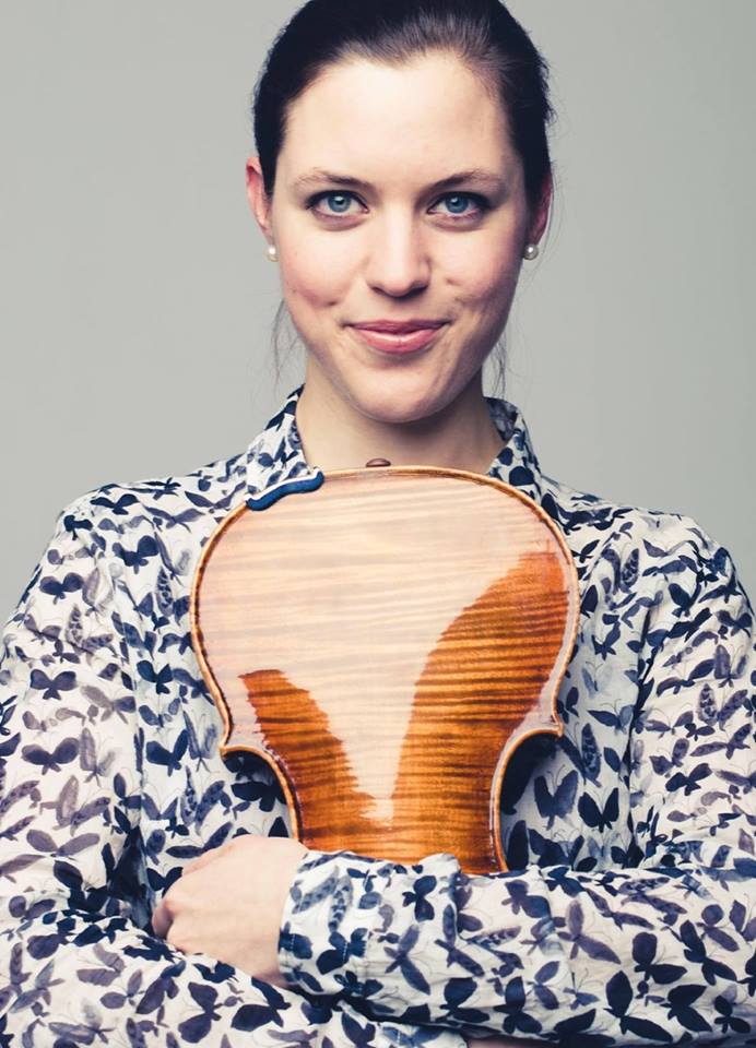 Na zdjęciu kobieta - Magdalena Sokalska - ma skrzyżowane na piersi ręce, którymi przyciska do ciała skrzypce.
