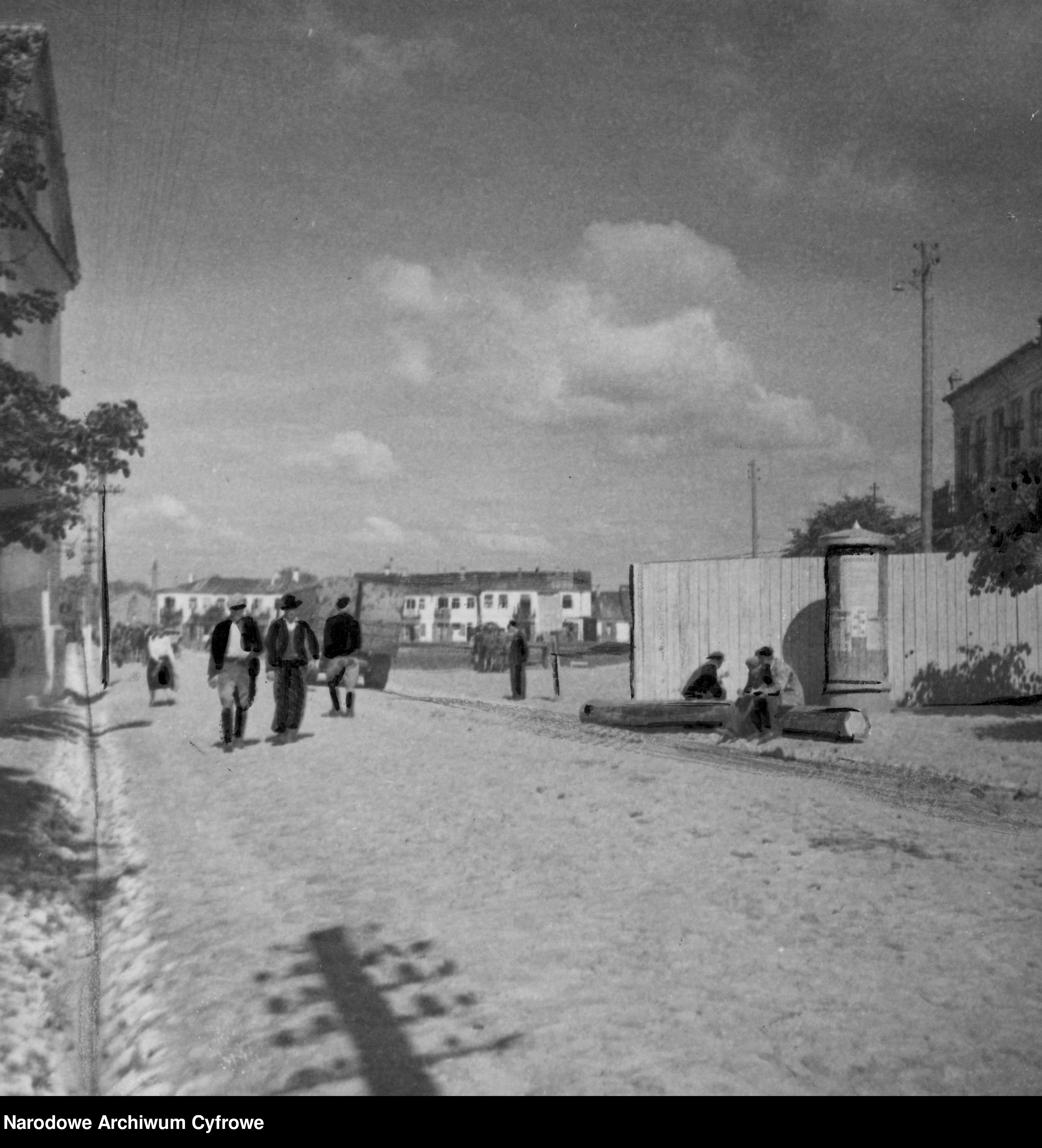Na obrazie widzimy archiwalne zdjęcie ukazujące ulicę w Getcie w Opolu Lubelskim. Fotografia jest czarno-biała.