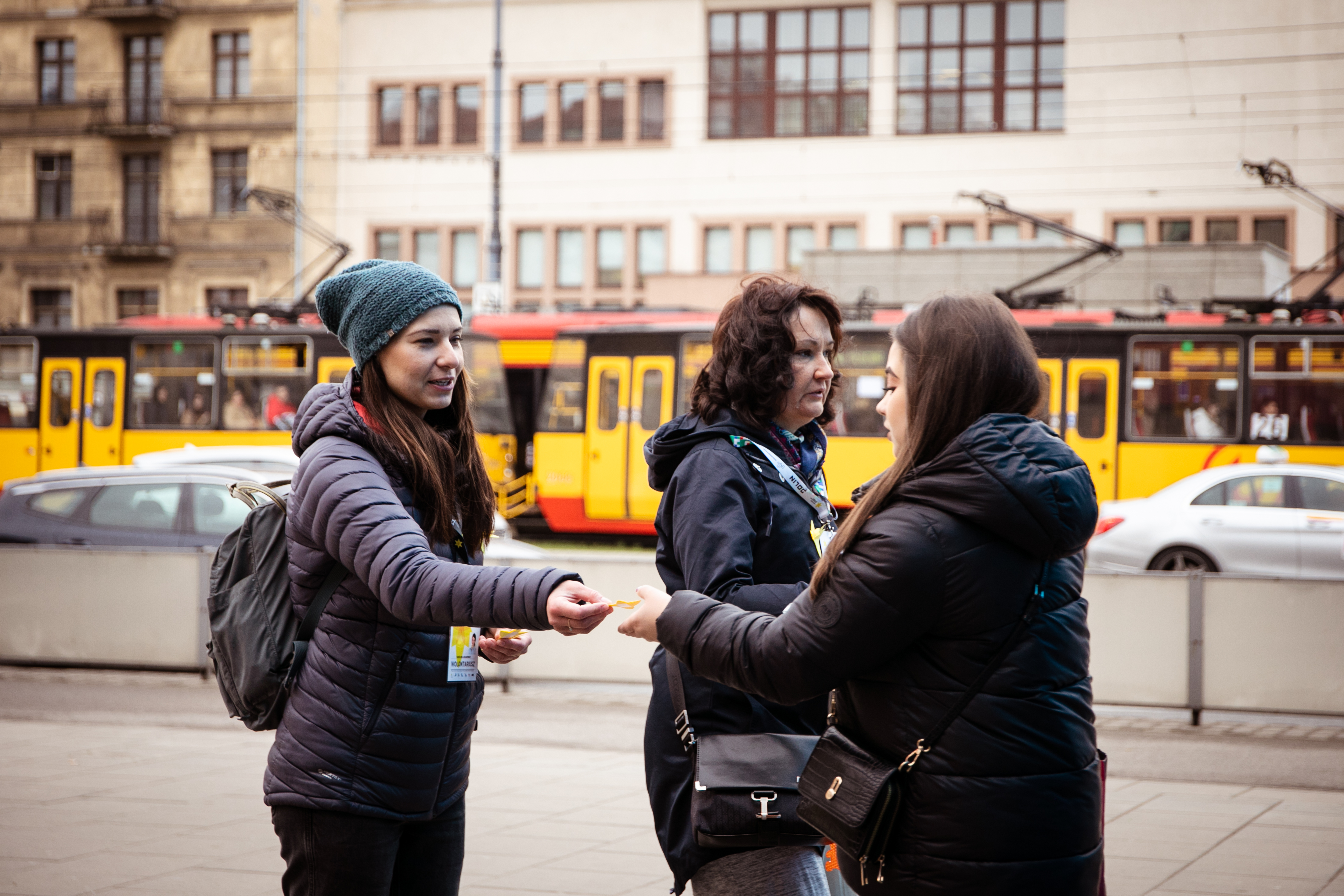 Dwie wolontariuszki rozdają papierowe żonkile na ulicach Warszawy.