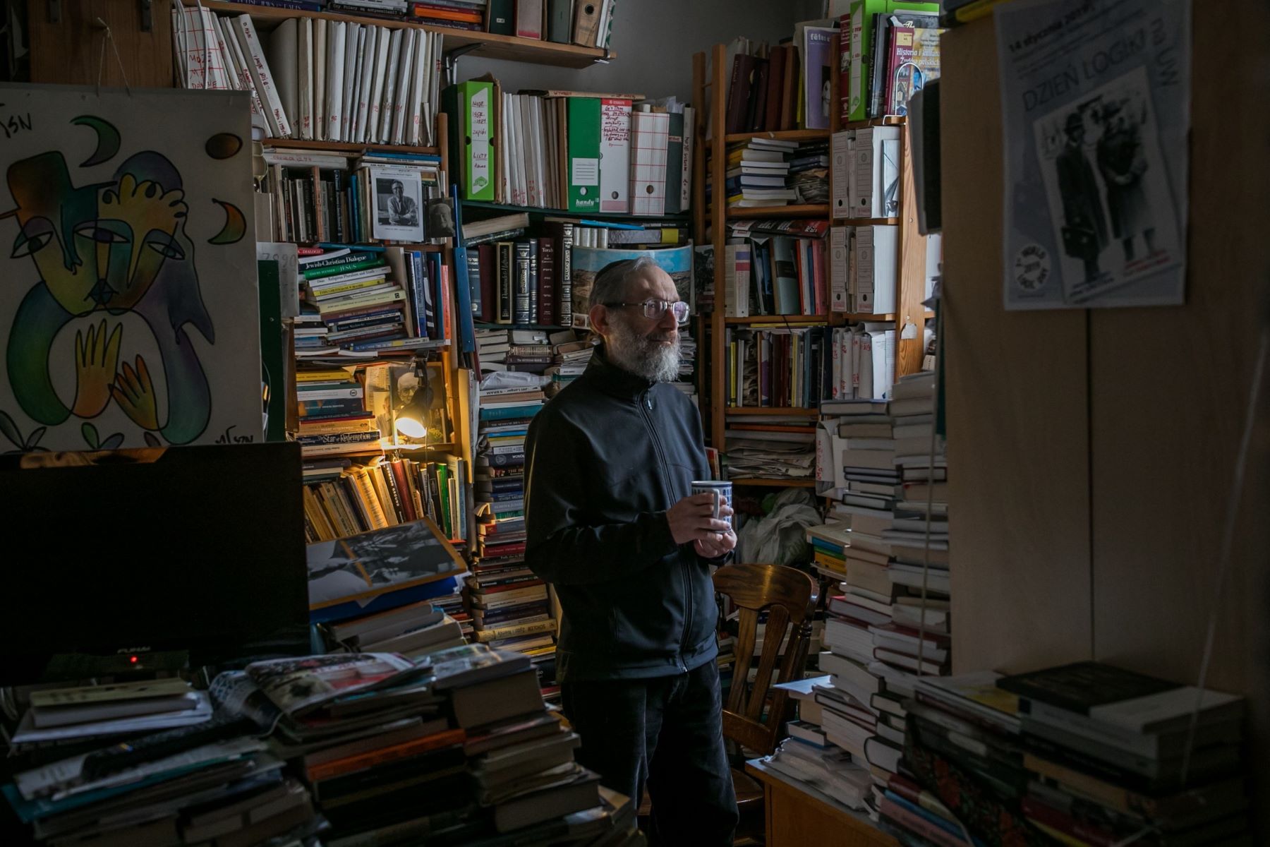 Stanisław Krajewski, starszy mężczyzna z brodą, w pokoju pełnym książek.