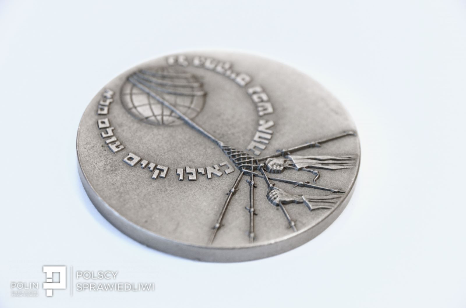 Medal "Sprawiedliwy wśród Narodów Świata" - posrebrzany, z wyrytymi symbolami i inskrypcją "Kto ratuje jedno życie, ratuje cały świat".
