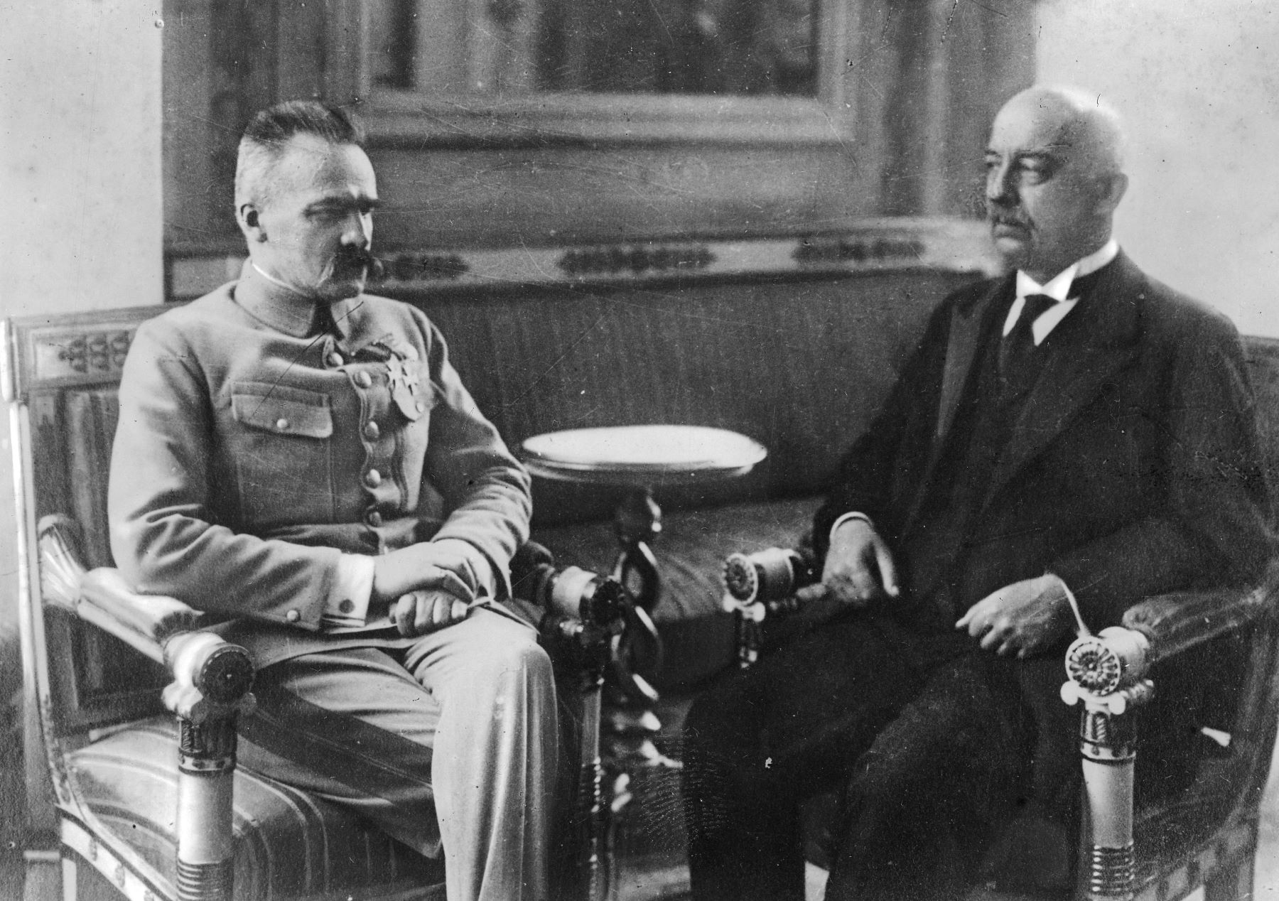 Gabriel Narutowicz z Józefem Piłsudskim siedzą obok siebie podczas spotkania w Belwederze.