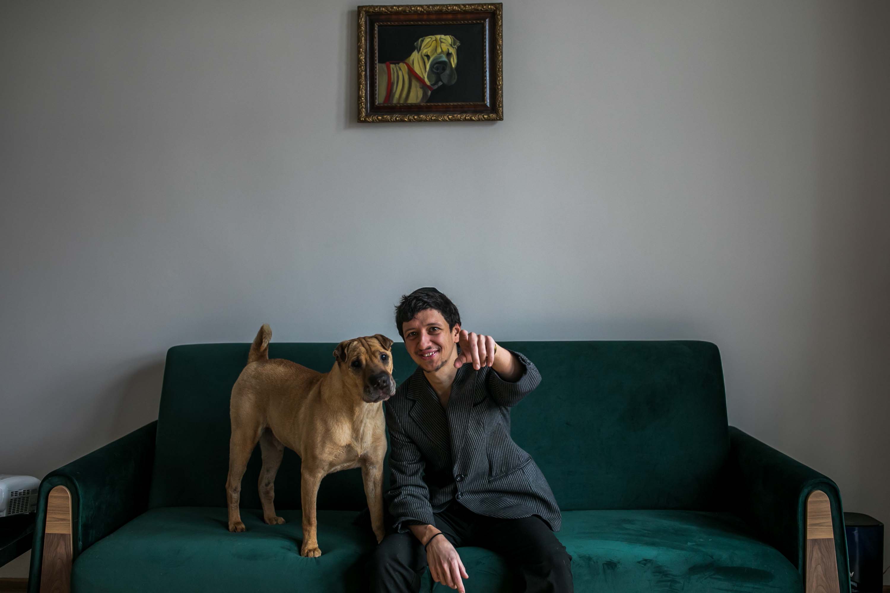 Dawid Gurfinkiel siedzi na kanapie ze swoim psem.