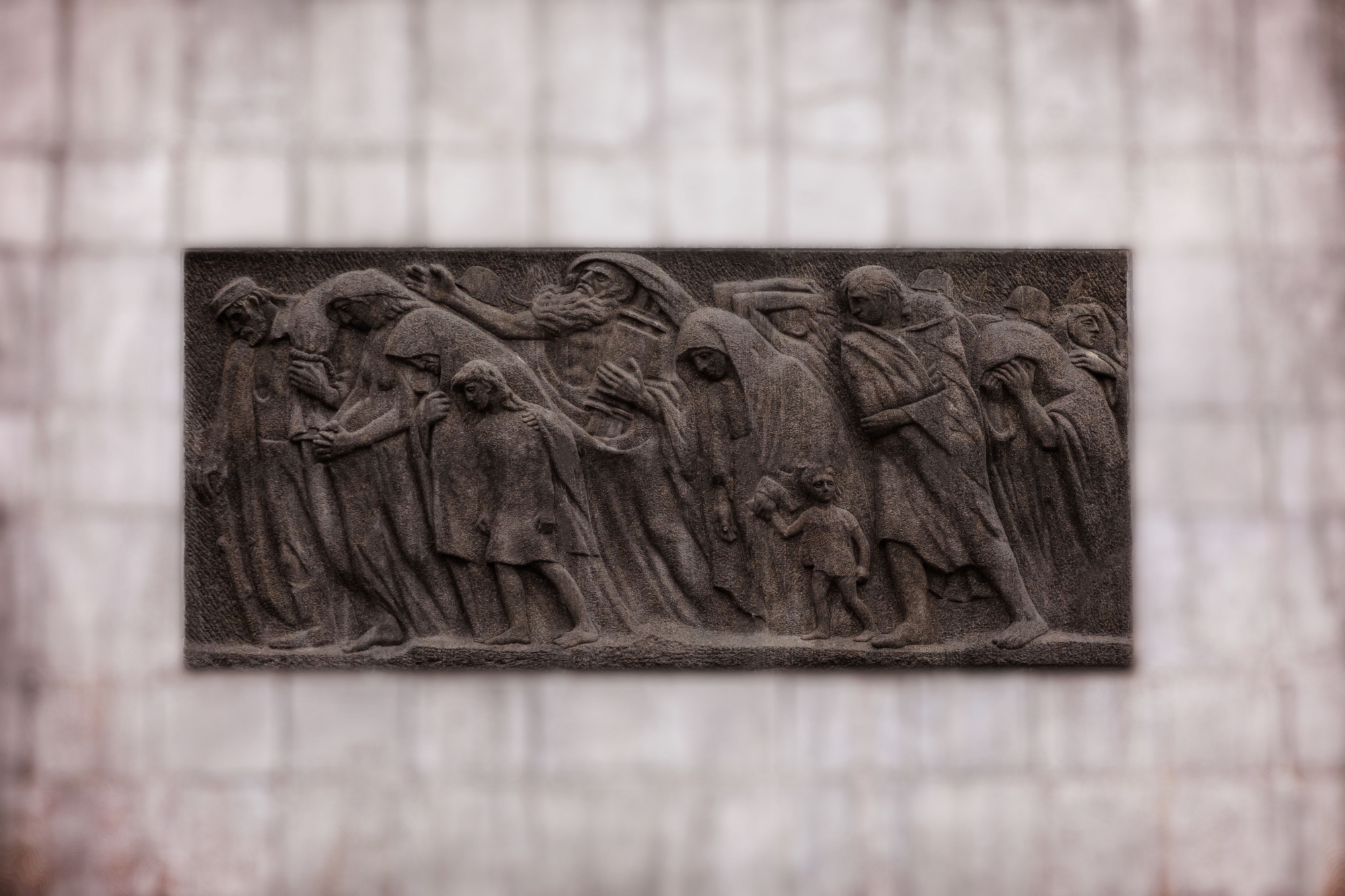 Relief na drugiej stronie pomnika Bohaterów Getta przedstawiający pochód cywilów.