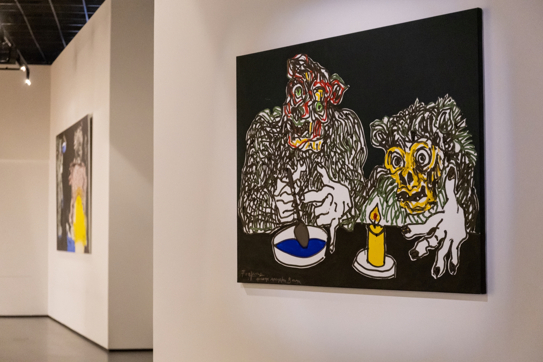 Na białej ścianie wiszą dwa obrazy Andrzeja Fogtta z serii "Bucza".