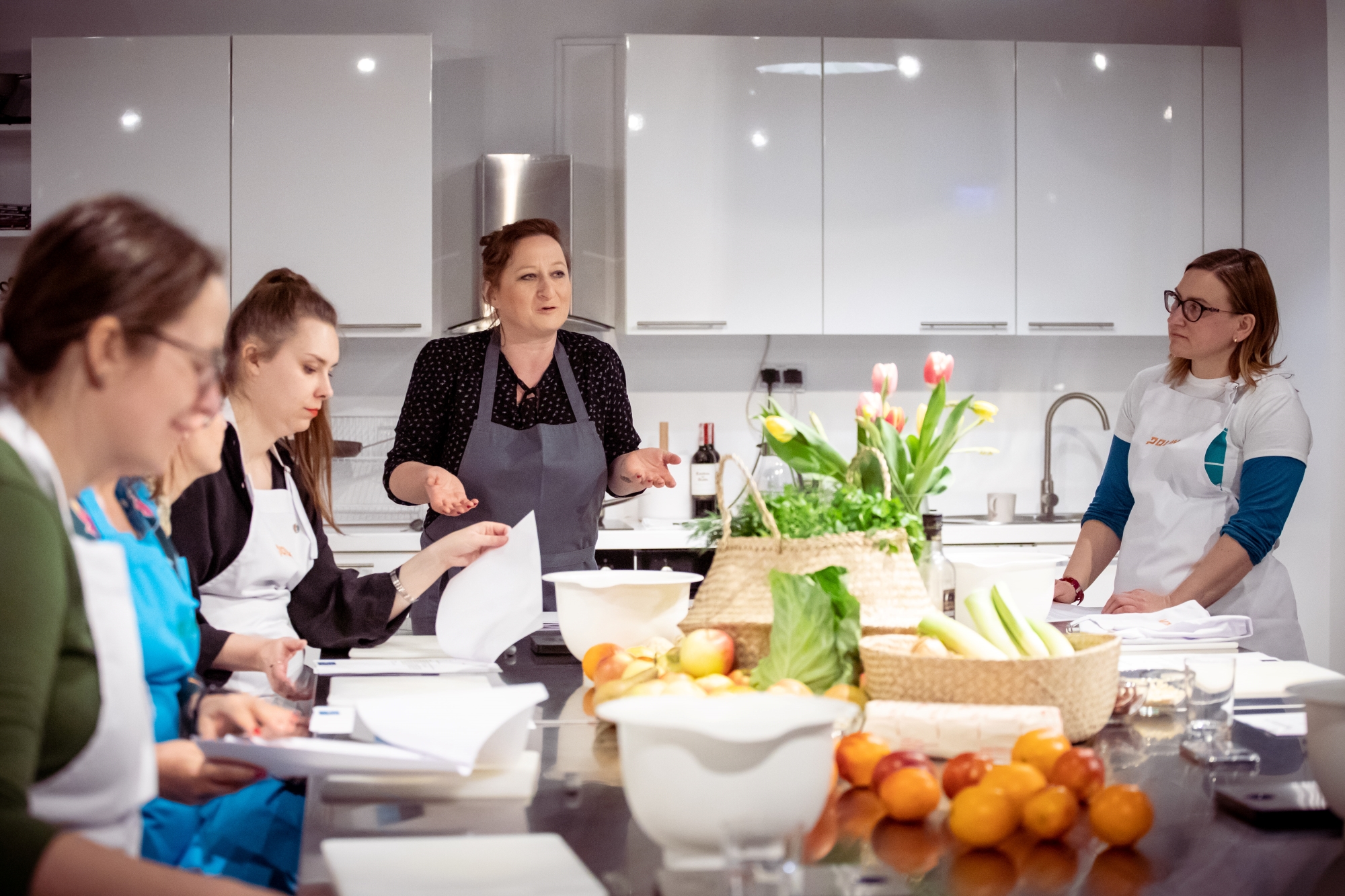 Sabina Francuz i uczestnicy warsztatów stoją przy stole w Pracowni Kulinarnej "U Fani".