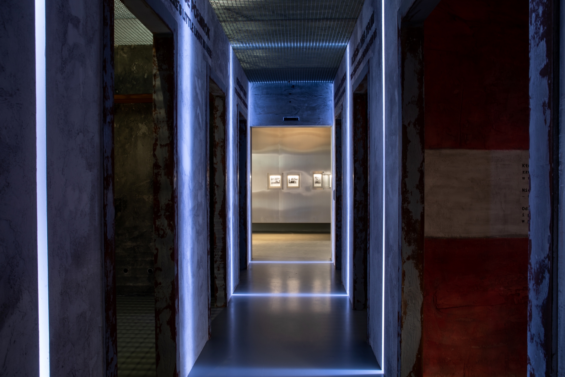 Ciemne przestrzenie na wystawie "Wokół nas morze ognia" - podświetlone jedynie krawędzie ścian w korytarzu.