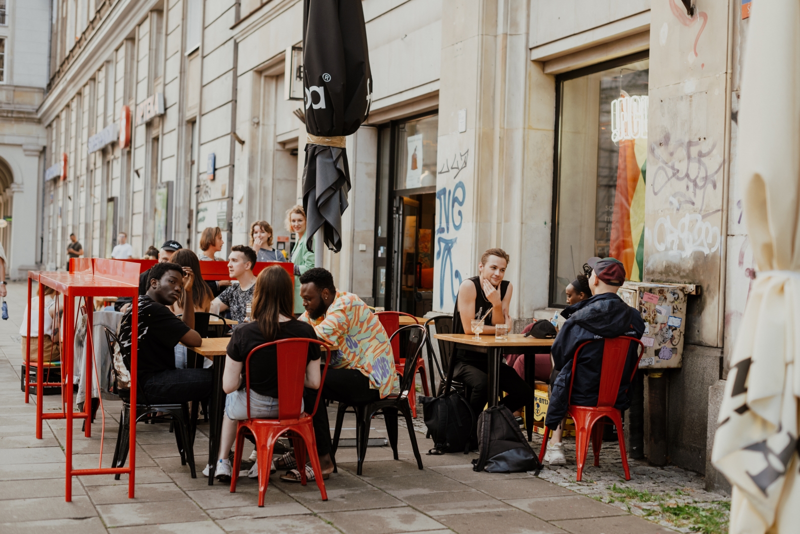 Członkowie Stowarzyszenia Inclusive.Buzz siedzą przy stolikach w warszawskiej kawiarni.