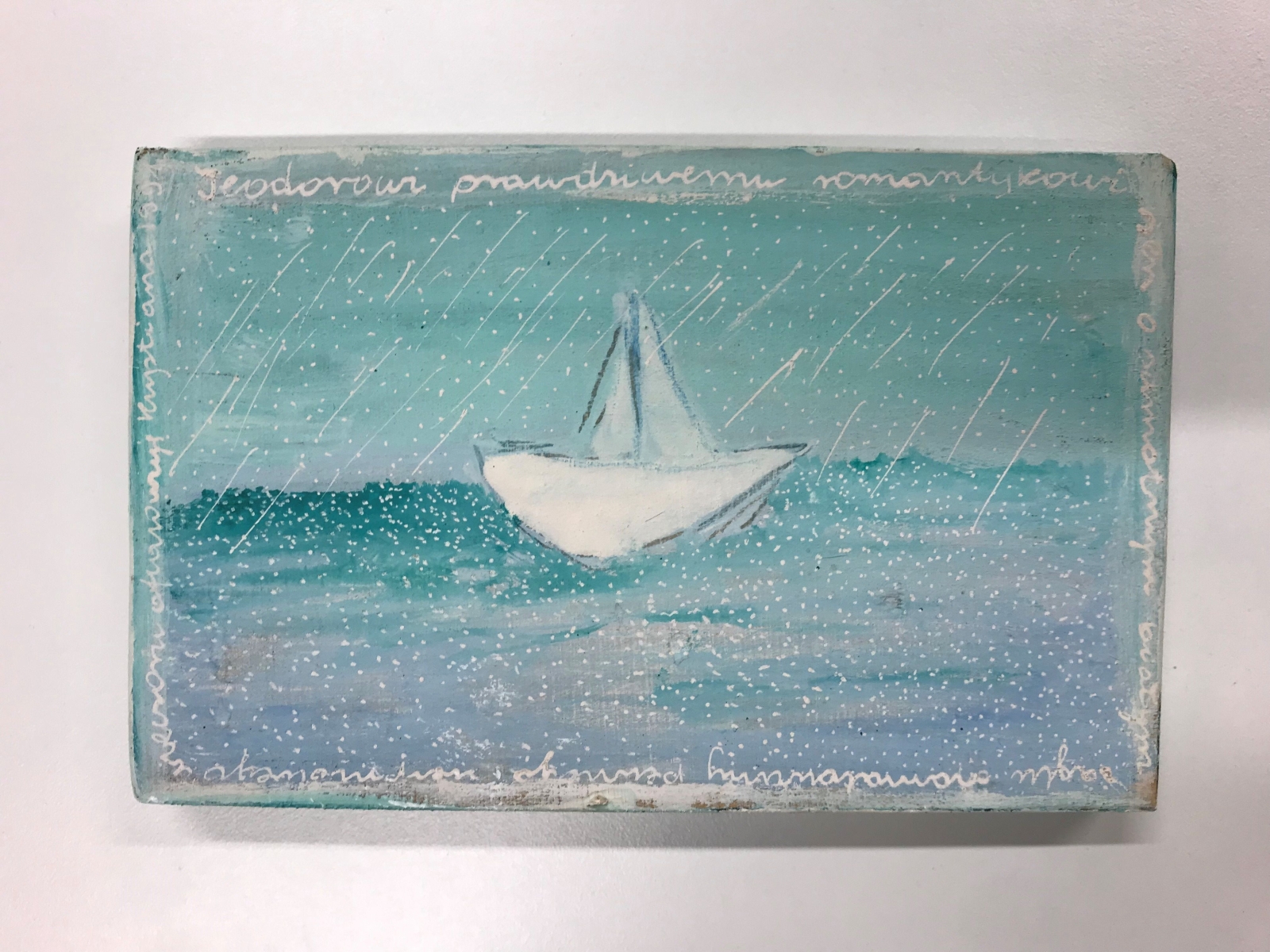 Praca Krystiany Robb-Narbutt: na morzu, wśród deszczu, płynie biała żaglówka.