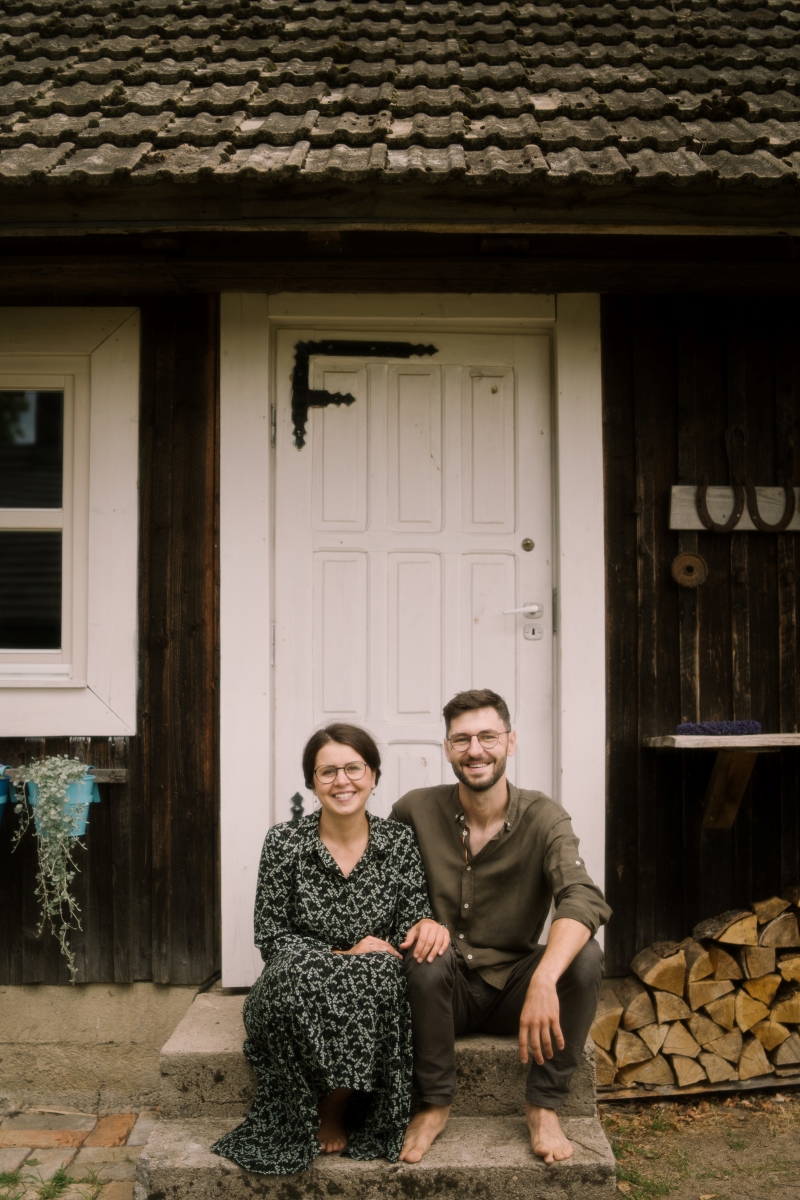 Ula i Grzegorz Kopciewscy siedzą na schodach przed swoim domem w Dworzysku.