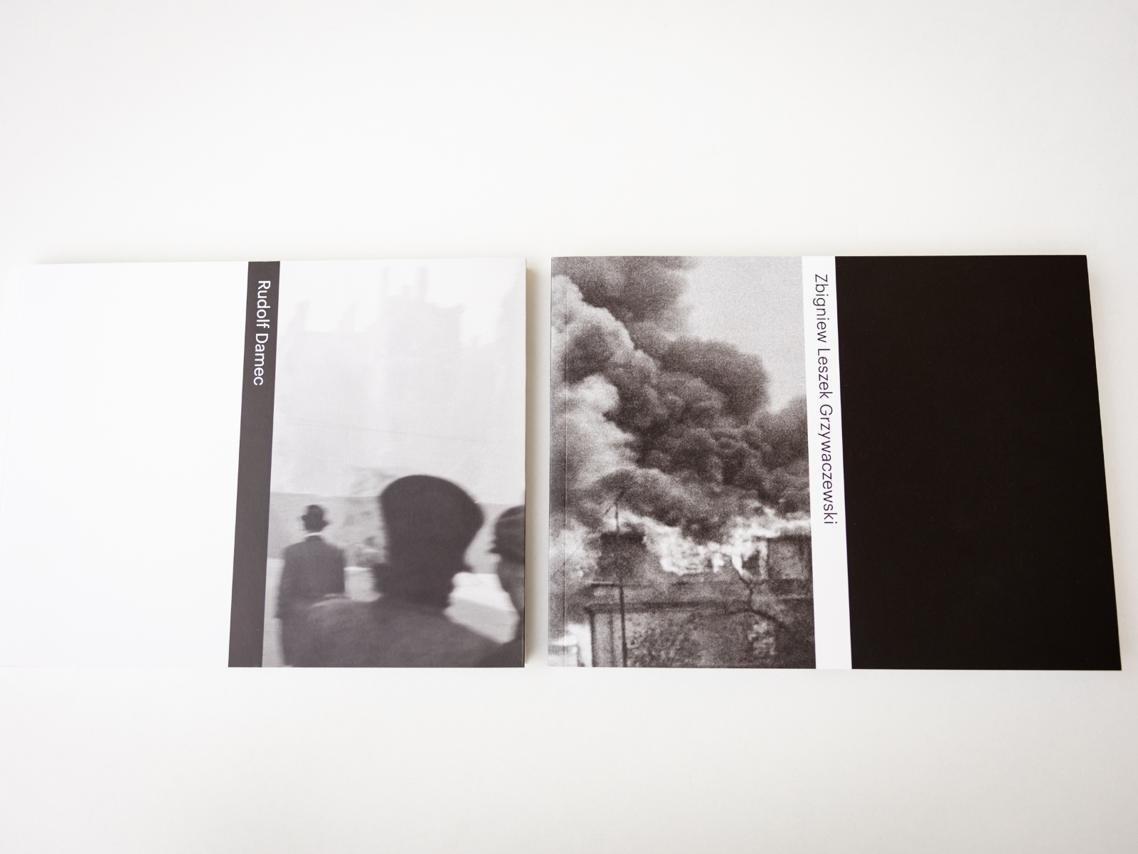 Albumy zdjęć Dameca i Grzywaczewskiego leżą obok siebie. Na okładkach wybrane fotografie.