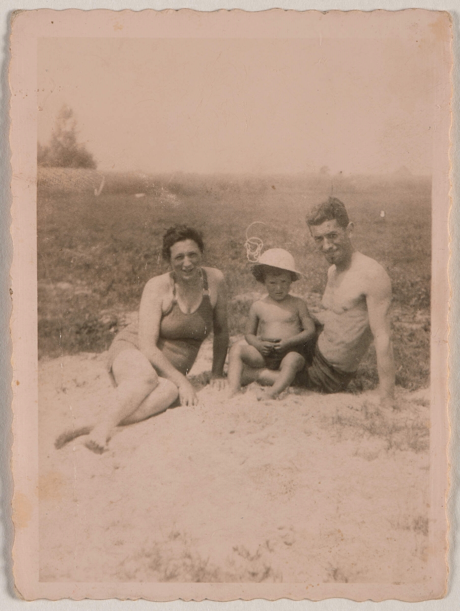 Chana Terbiler, Abram Kacman i ich syn Walisz siedzą na plaży.