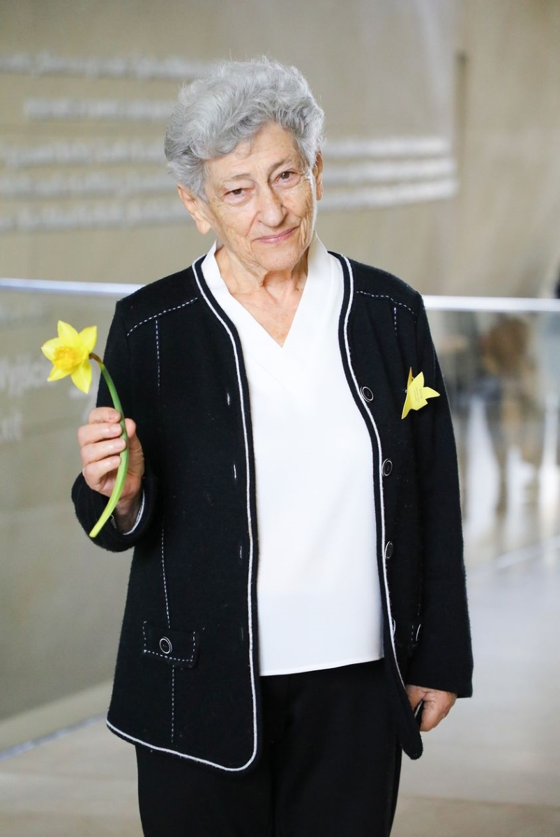 Krystyna Budnicka holds a daffodil in her hand.