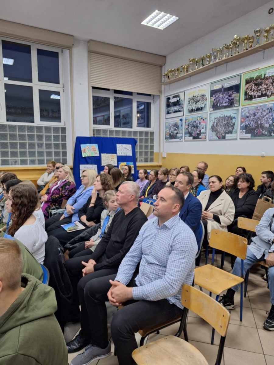 Uczestnicy i uczestniczki wieczoru pamięci w Warcie siedzą na krzesłach w sali.