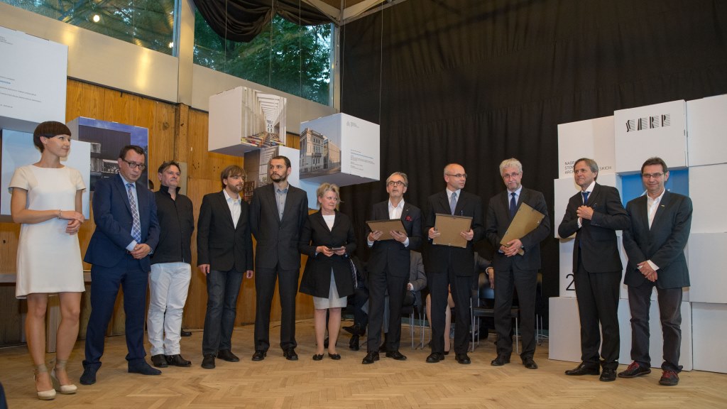Grupa nagrodzonych osób stoi w rzędzie.