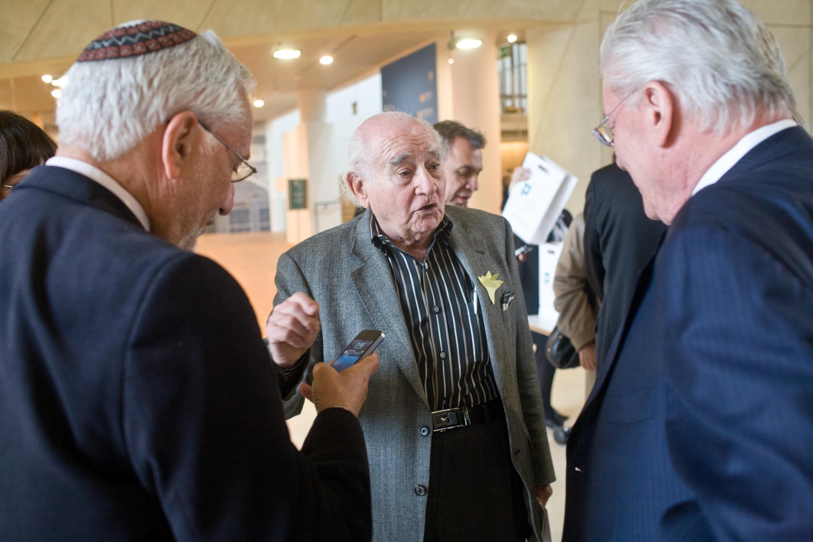 Trzech mężczyzn rozmawia ze sobą w holu głównym Muzeum POLIN podczas akcji Żonkile w 2013 r.