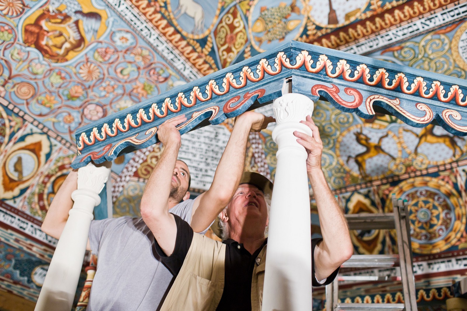 Mężczyźni mocują elementy bimy, która wchodzi w skład zrekonstruowanej synagogi w Muzeum POLIN.
