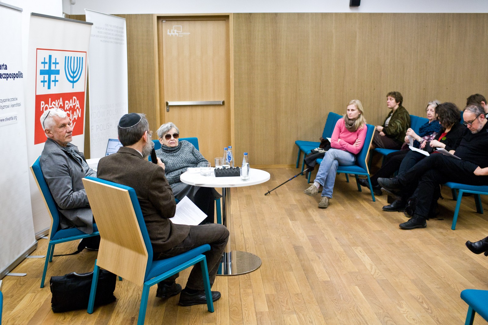 Paneliści i uczestnicy dyskusji "Uwierzyć w muzeum" siedzą w sali.