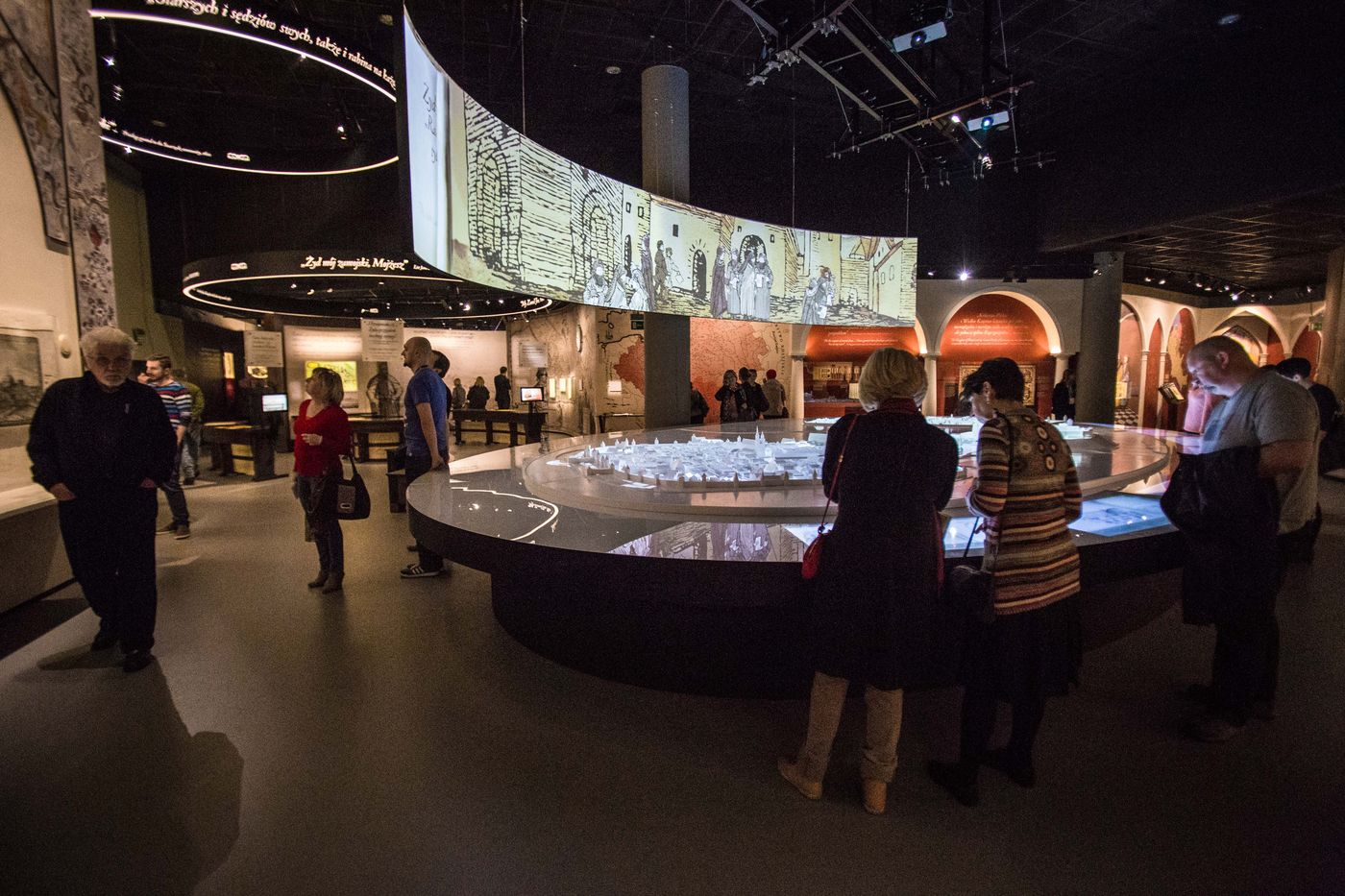Grupa ludzi zwiedza wystawę stałą w Muzeum POLIN.