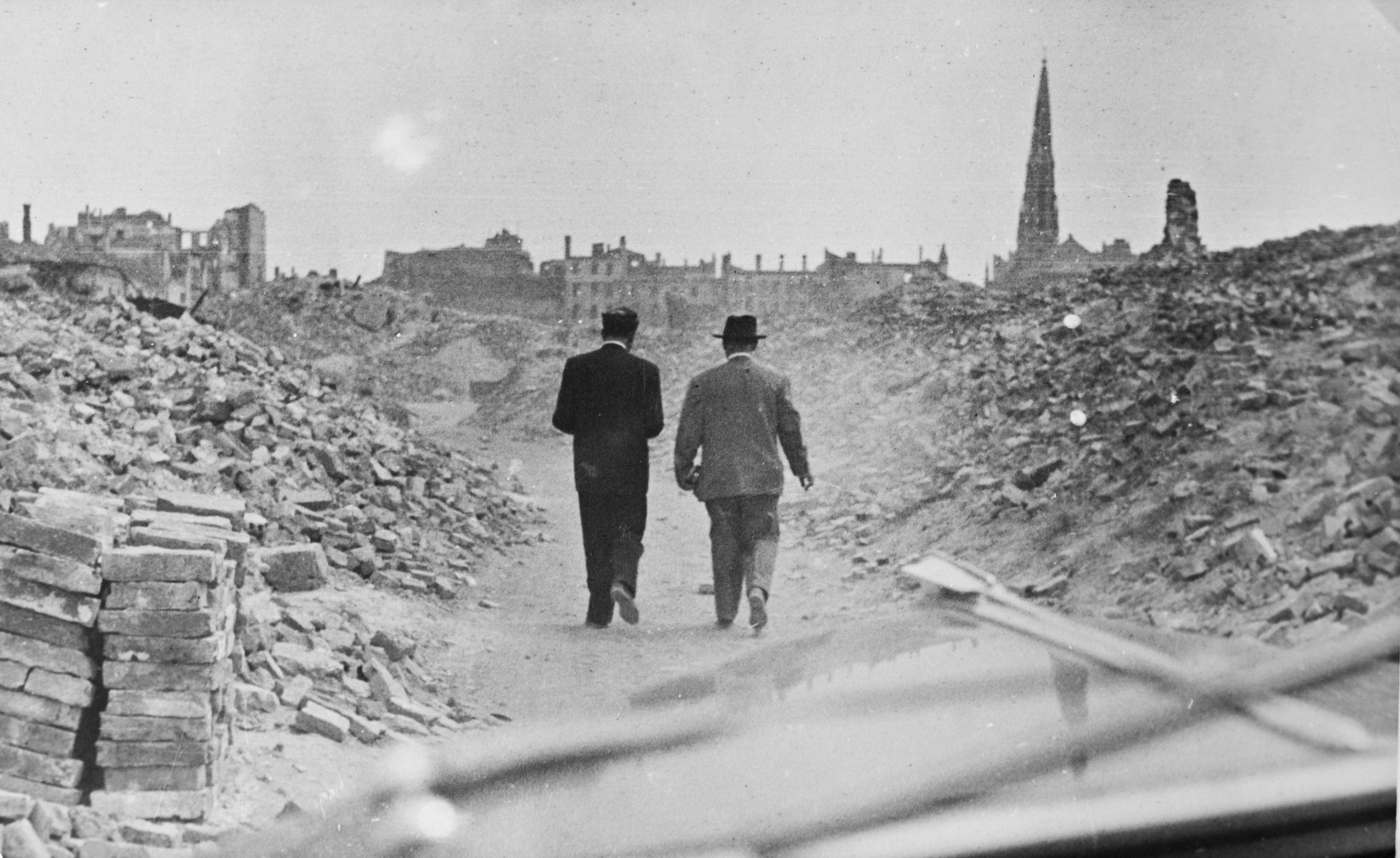Dwie osoby przy ruinach getta warszawskiego.