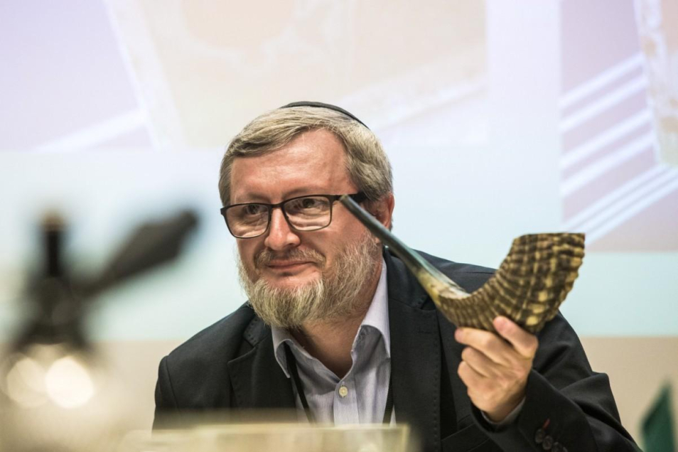 Na zdjęciu mężczyzna (Piotr Kowalik), trzyma w dłoniach róg