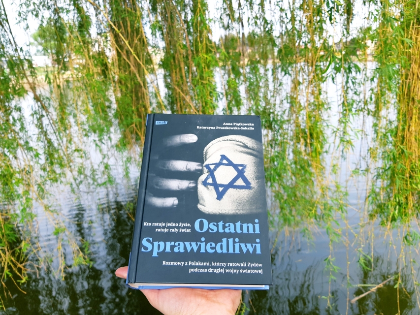 Okładka książki Anna Piątkowska, Katarzyna Pruszkowska-Sokalla "Ostatni Sprawiedliwi". W tle gałęzie wierzby płaczącej z młodymi listkami.