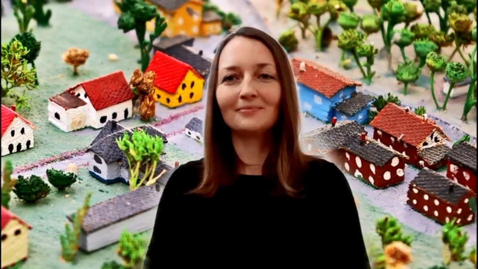 Grafika ilustracyjna: kobieta na tle grafiki z małym miasteczkiem