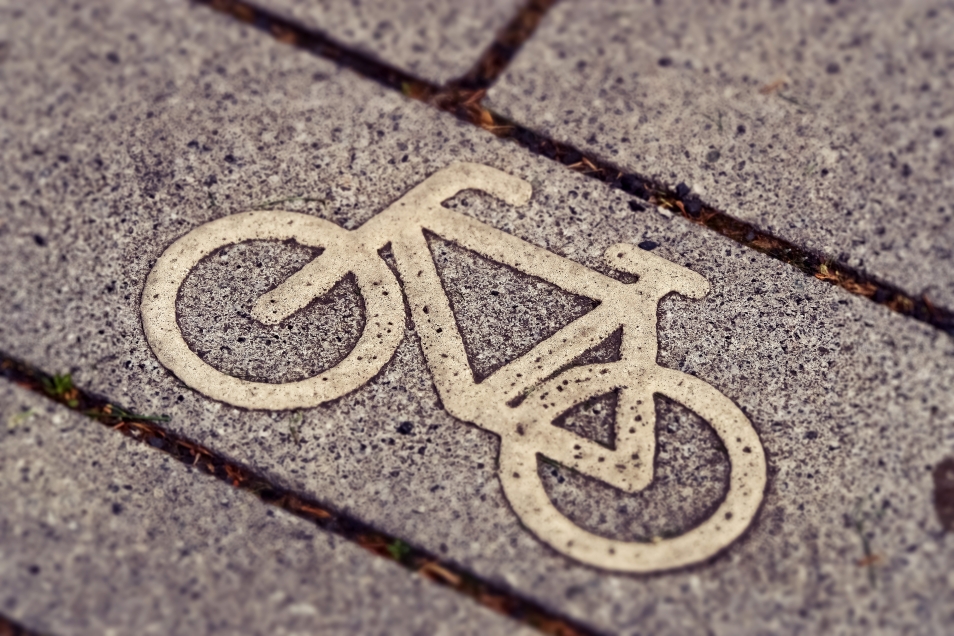 Na obrazie widzimy symbol roweru, narysowany na kostce, która wybrukowana jest ścieżka rowerowa. 