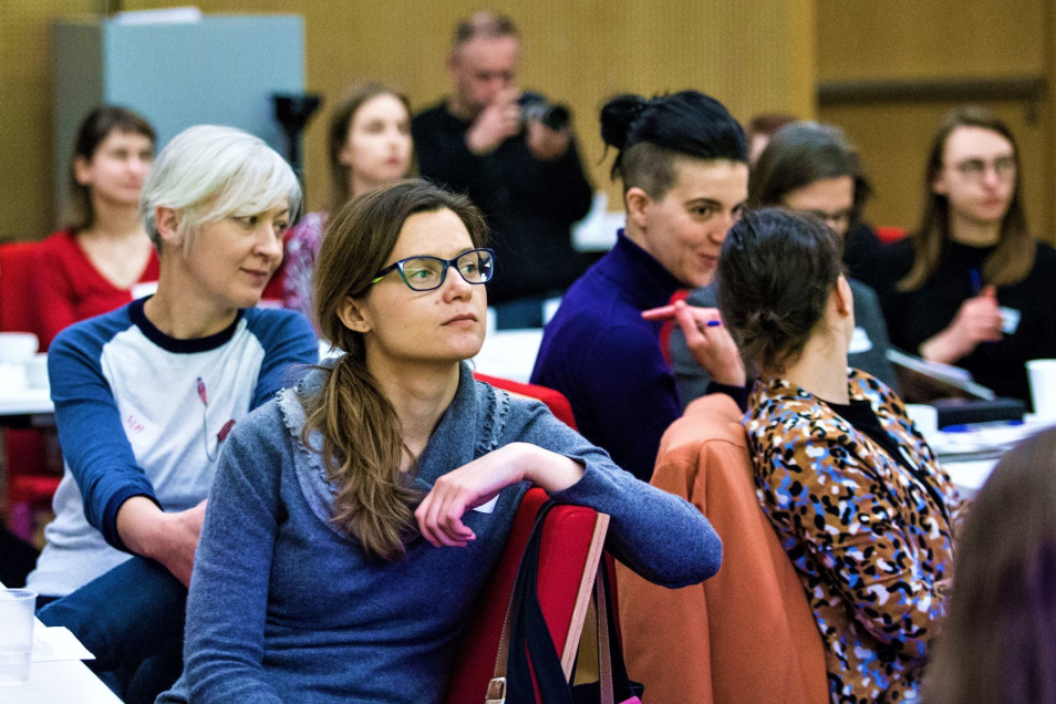Grupa uczestniczek konferencji edukacyjnej siedzi w sali w Muzeum POLIN. W tle jakiś mężczyzna robi zdjęcia.