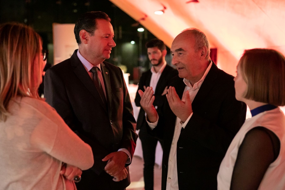 Zygmunt Stępiński, Yacov Livne, Magdalena Maślak rozmawiają ze sobą w holu głównym Muzeum POLIN.