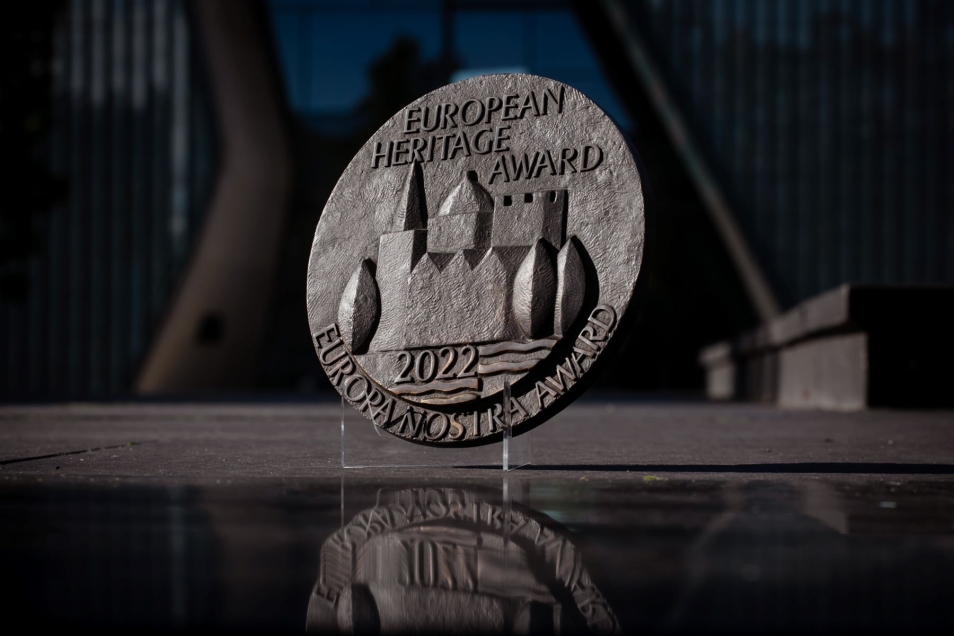 Statuetka Nagrody Dziedzictwa Europejskiego / Europa Nostra 2022 na tle budynku Muzeum POLIN.