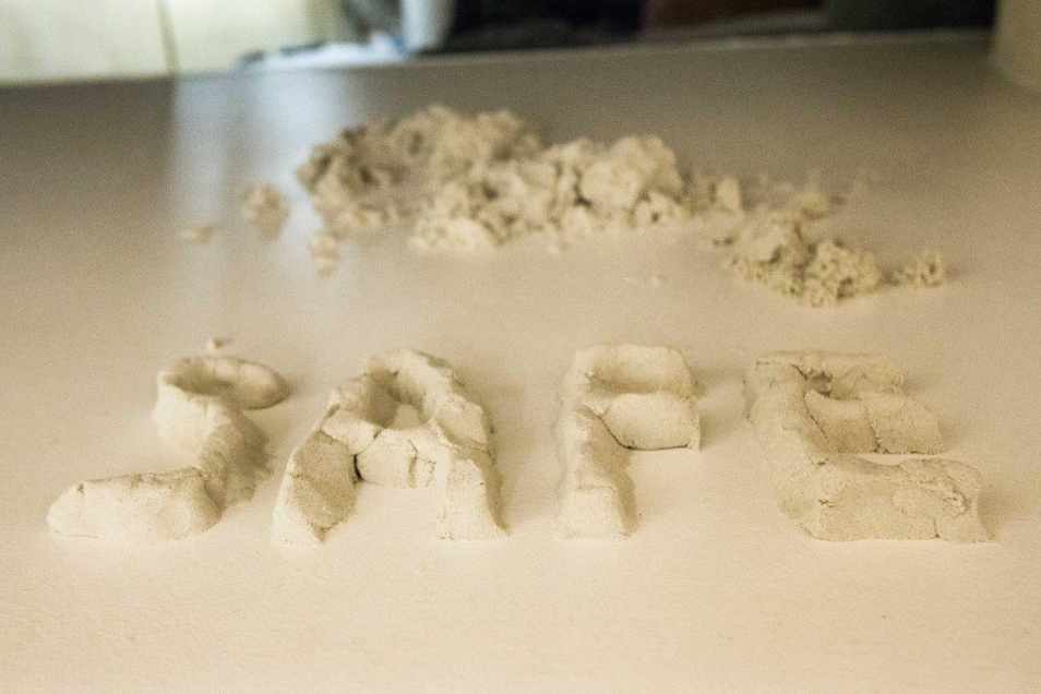 na podłodze w kolorze piasku, usypany z piasku napis SAFE, Tetiana Bohuslavska, Warszawa 2022