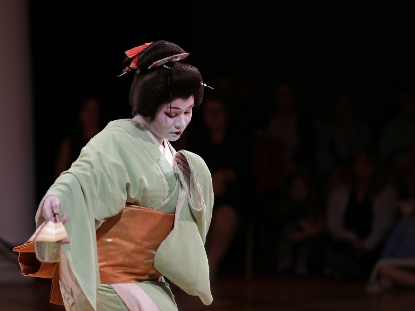 Azjatka ubrana w kimono, z twarzą pomalowaną na biało, z włosami spiętymi w kok.