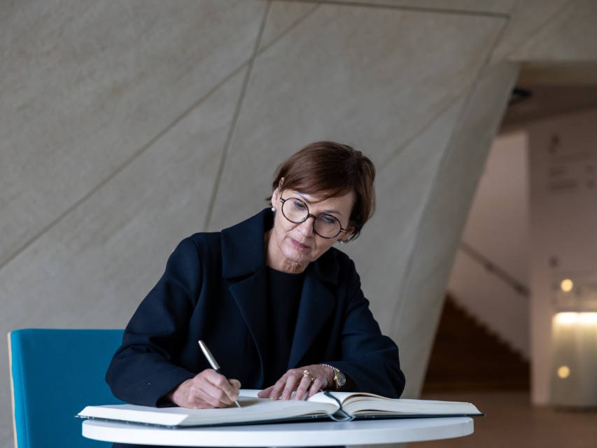 Bettina Stark-Watzinger wpisuje się do księgi pamiątkowej.