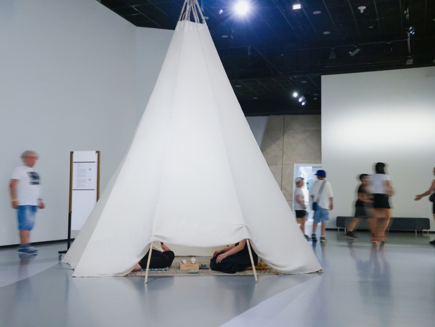 Dwie kobiety siedzą w namiocie podczas performansu "In II Tent" w Muzeum POLIN.