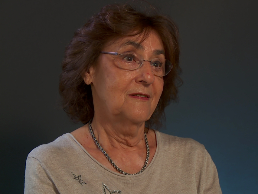 Barbara Schmid - brunetka w średnim wieku, na nosie ma okulary, a na szyi łańcuszek.