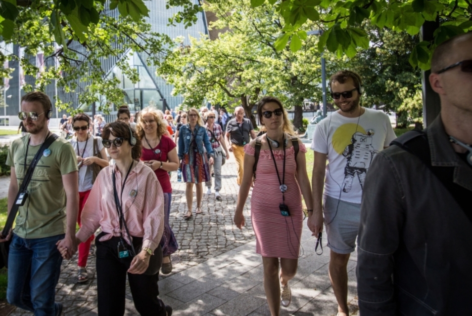 A group of people during a city walk in the vicinity of the POLIN Museum.