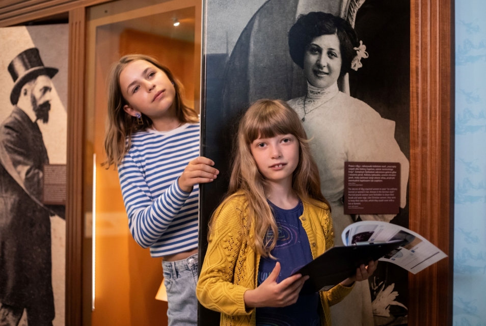 Dwie dziewczynki stoją na wystawie stałej w Muzeum POLIN.