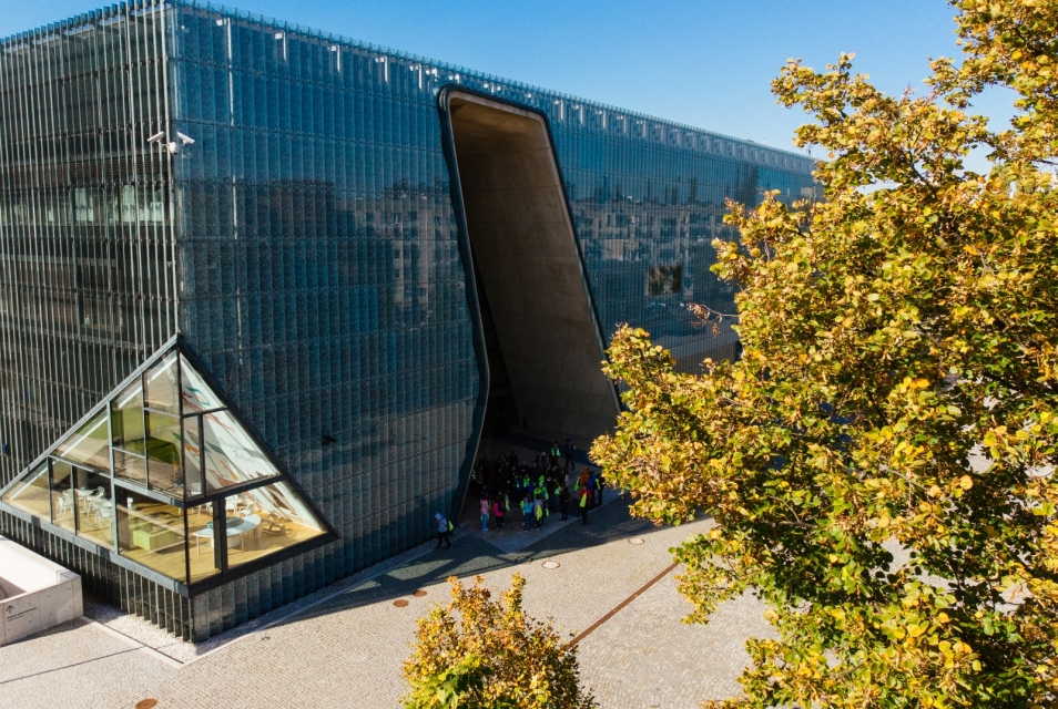The POLIN Museum building surrounded by trees.