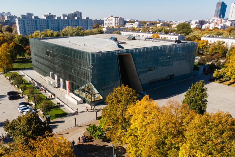 Budynek Muzeum POLIN wśród jesiennych drzew.