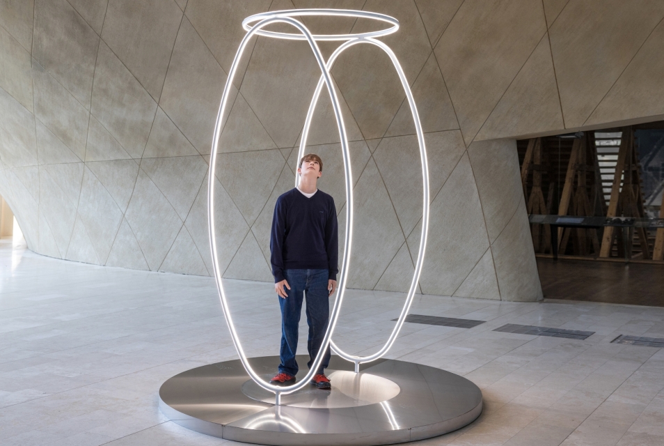 The boy stands inside the light installation ‘Echo’ in the main hall of POLIN Museum.