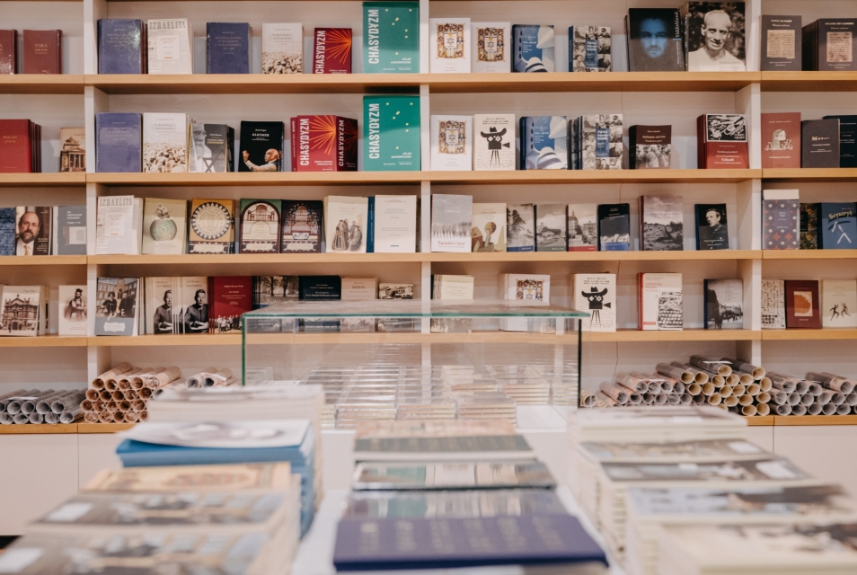 Books arranged on tables and shelves in the Austeria shop at POLIN.