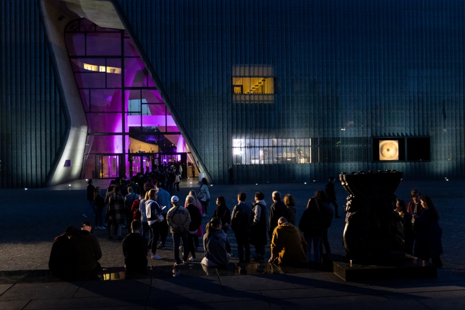 Night. A queue forms outside the POLIN Museum building during Museum Night.