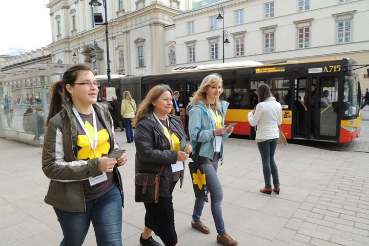 Trzy wolontariuszki idą Krakowskim Przedmieściem. 