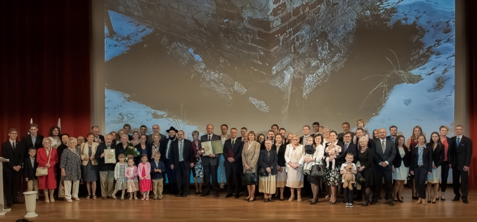 Grupa ludzi stoi na scenie.