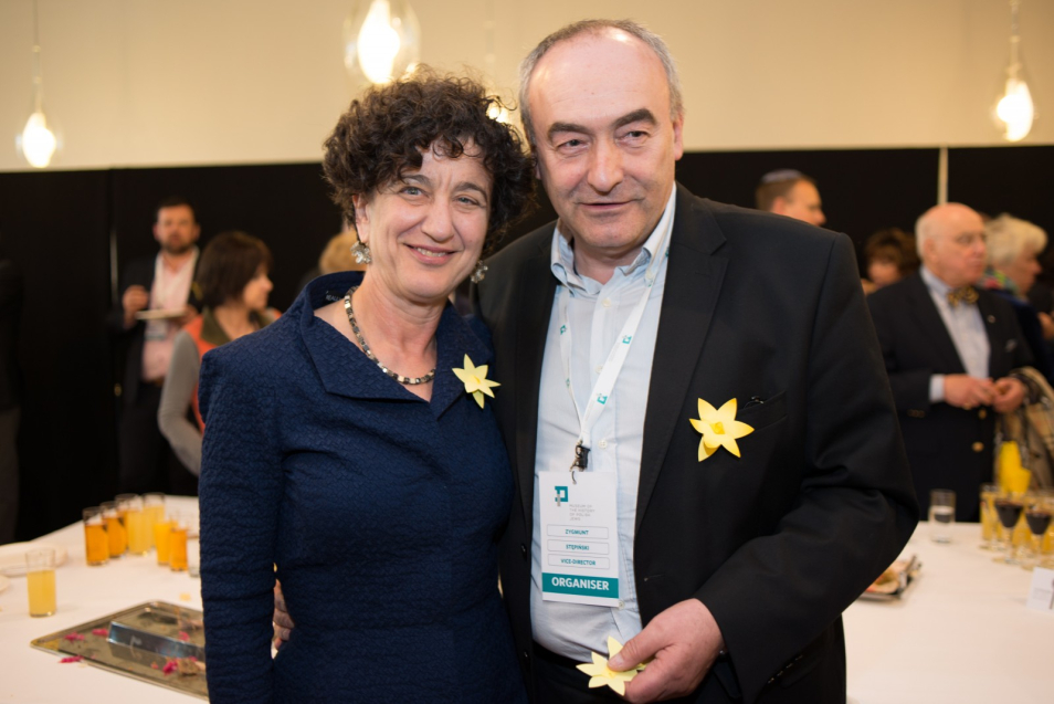 Akcja Żonkile 2013. Zygmunt Stępiński stoi z jakąś kobietą. Oboje mają przypięte do ubrań papierowe żonkile.