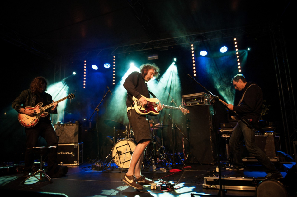 Wydarzenie podczas "Nocy Muzeów". Trzej gitarzyści na scenie grają koncert.