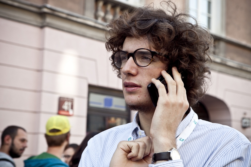 Chłopak trzyma telefon przy uchu.