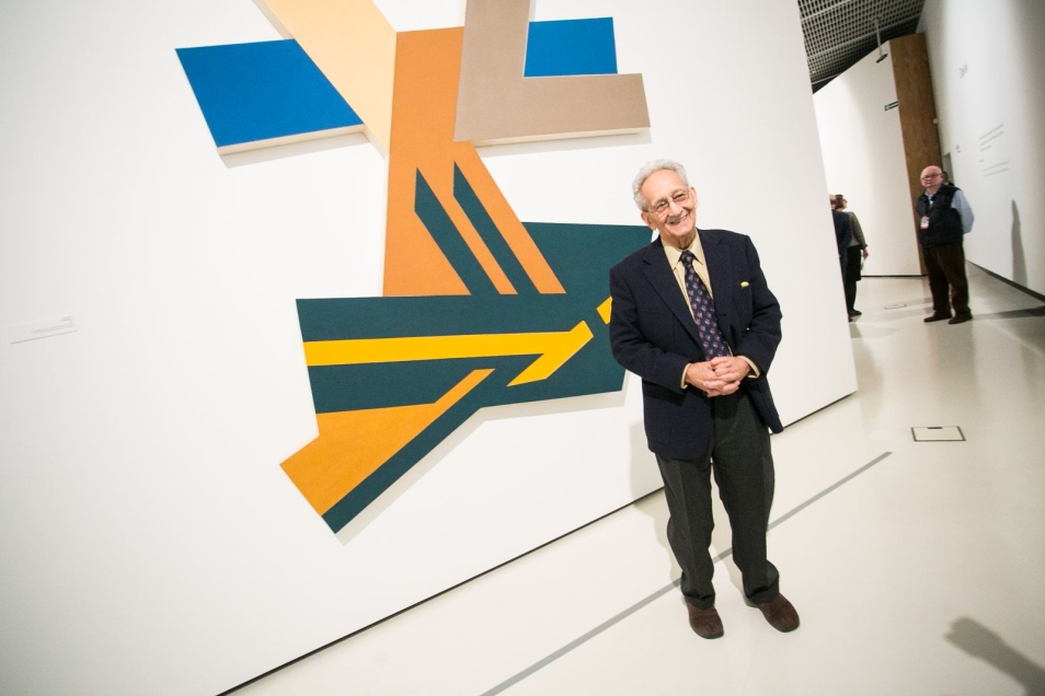 Frank Stella na wystawie "Frank Stella i synagogi dawnej Polski" stoi przed jedną ze swoich prac