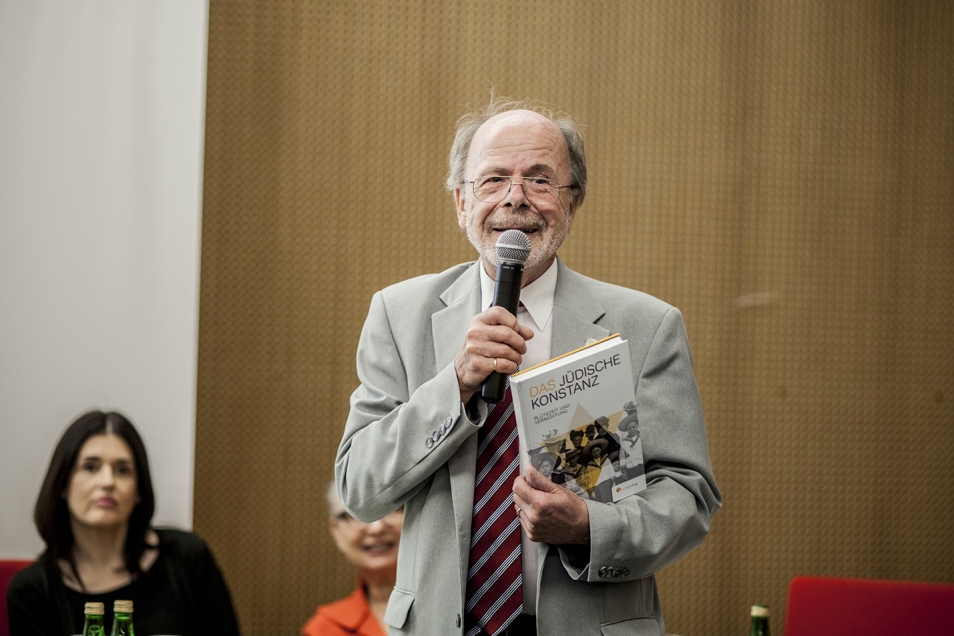 Mężczyzna mówi przez mikrofon.